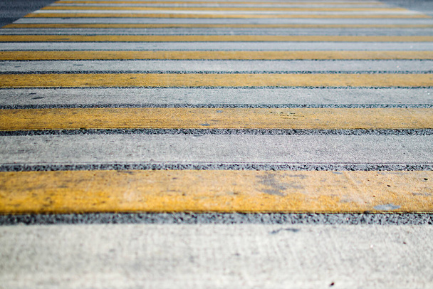 dirty yellow-white pedestrian crossing on a wide road. pedestrian safety on the streets. empty streets . - Фото, изображение