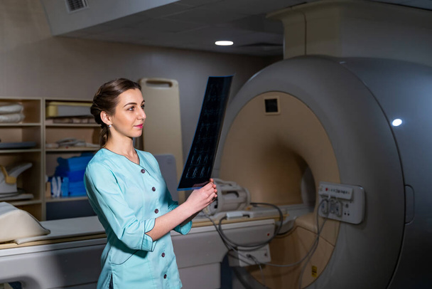 Doctor explaining an x-ray image near the magnetic resonance imaging machine. - Foto, Imagem