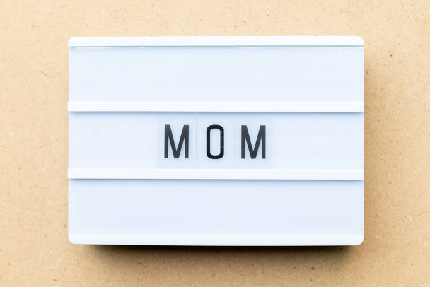 White lightbox with word mom on wood background - Foto, Imagem
