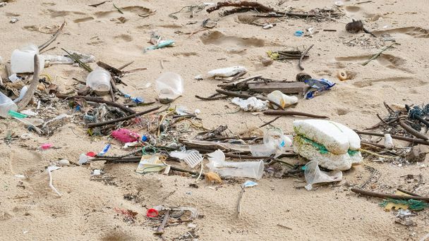 Contaminación ambiental. Problema ecológico. Basuras, plástico y desechos en la playa de arena del mar tropical
.  - Foto, Imagen