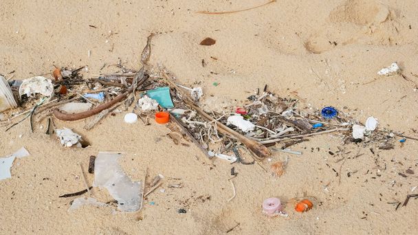 Contaminación ambiental. Problema ecológico. Basuras, plástico y desechos en la playa de arena del mar tropical
.  - Foto, Imagen