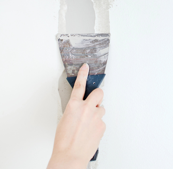 Mão feminina reparos parede com pasta spackling
 - Foto, Imagem