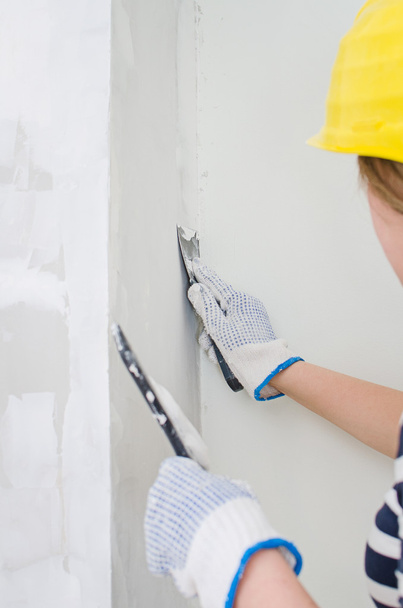 θηλυκό γυψαδόρο επισκευές τοίχων με η κόλλα - Φωτογραφία, εικόνα