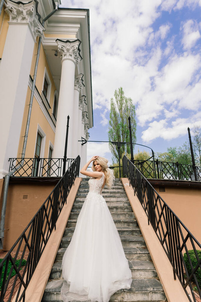 Minsk, Belarus - 05.05.2020. Young attractive blonde bride with curly hair walking in the park and smiling, concept wedding - Fotografie, Obrázek
