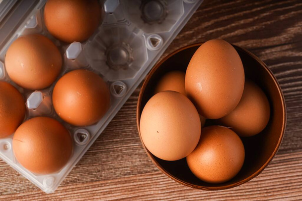 A carton of eggs on a wooden background - Photo, Image