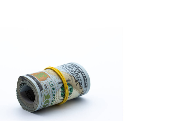 100 dollars rolled into a roll isolated on white background. concept wealth, criminal money, illegal business. - Photo, Image