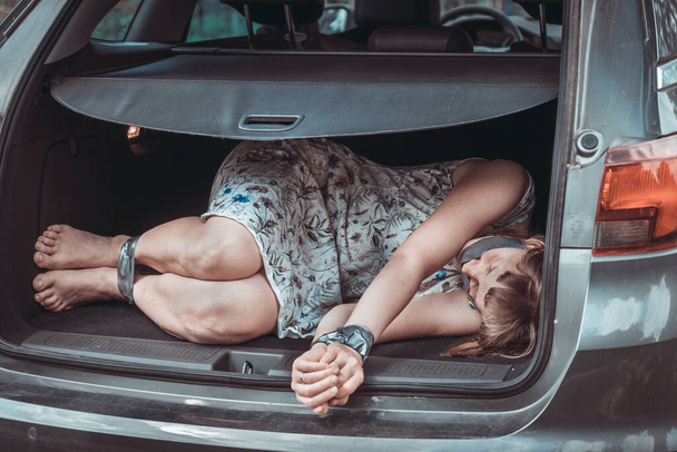  Woman with tied hands inside car trunk - kidnapping - Foto, Imagen