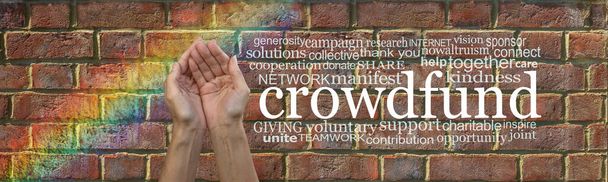 Donations needed for our crowd funding campaign - female cupped hands beside the word CROWDFUND surrounded by a relevant word cloud against a  brick wall background with a flash of rainbow on left - Photo, Image