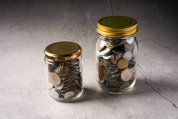 Conceito de poupança: moedas em frasco com espaço de cópia para texto
 - Foto, Imagem