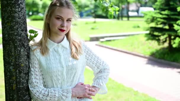 Girl with great makeup posing in sunny weather. Video of a pretty blonde in a park with a smile. - Video