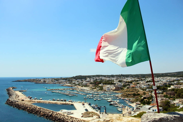 Vista superior da cidade de Santa Maria di Leuca, em Salento, Puglia, Lecce, Itália. O mar, o céu azul e a marina. Uma bandeira da Itália acenando em primeiro plano
. - Foto, Imagem