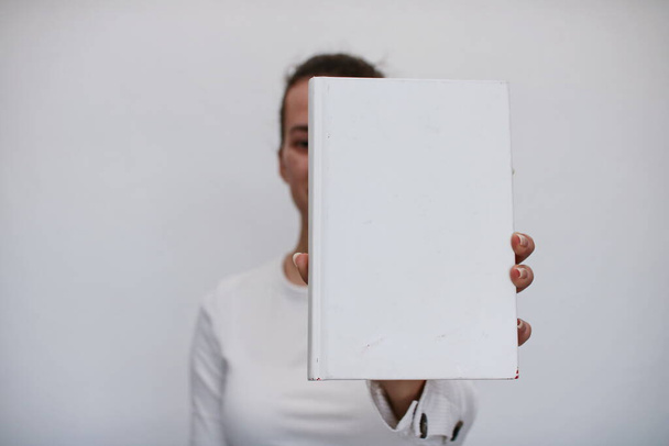  Mladá dívka drží v ruce knihu - Fotografie, Obrázek