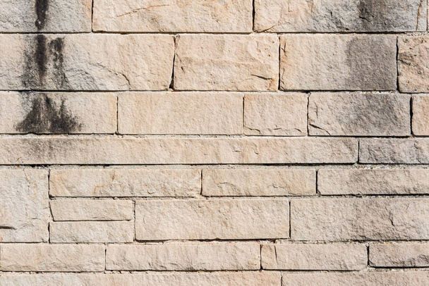 Achtergrond: grijze verweerde stenen muur - Foto, afbeelding