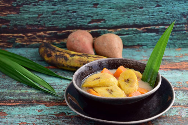 Индонезийский десерт, Kolak Pisang Ubi, Banana and Sweet Potato Compote. Сделано из банана, приготовленного из кокосового молока, пальмового сахара и листьев пандана. Очень популярен во время Рамадана.  - Фото, изображение