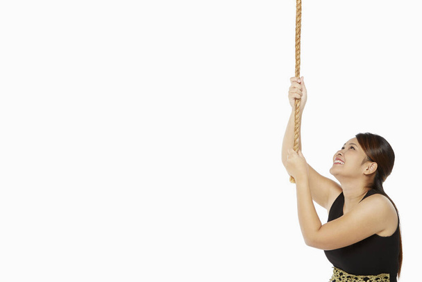 Woman holding on to a rope - Foto, imagen