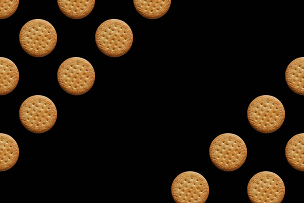 Muster mit multiplizierten kreisenden Keksen auf schwarzem Hintergrund. Platz für Text. Hochwertiges Foto - Foto, Bild