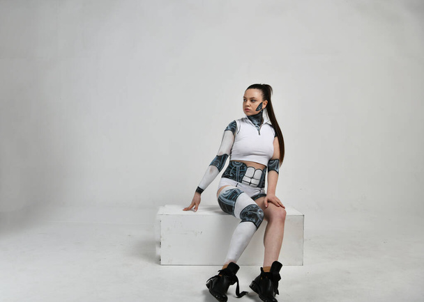 lány egy robot öltöny pózol különböző pózok fehér háttér - Fotó, kép