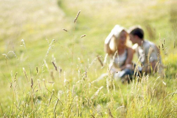 Una pareja sentada juntos en la pradera - Foto, Imagen