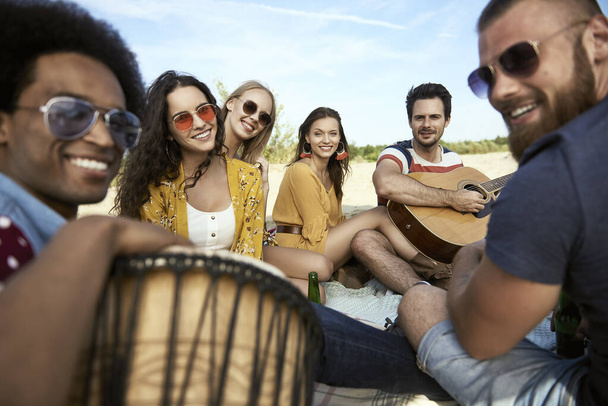 Portrait d'amis heureux assis sur la plage avec des instruments de musique
 - Photo, image