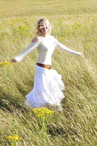 Een vrouw die gelukkig op de prairie rent. - Foto, afbeelding