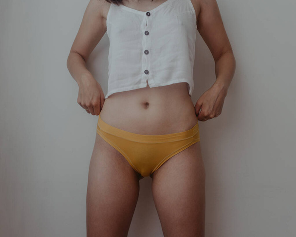 femme hanches et estomac en lingerie jaune - Photo, image