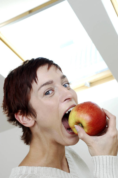 молода жінка кусає яблуко
 - Фото, зображення