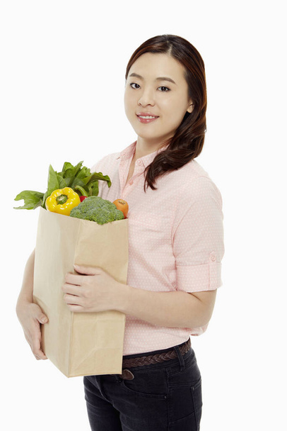 Cheerful woman with a bag of groceries - Zdjęcie, obraz