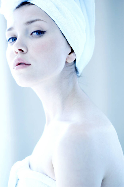Side shot of a woman with her hair and body wrapped up in towel - Fotografie, Obrázek