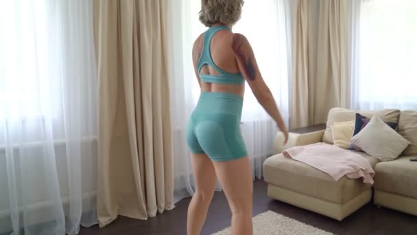 recovery of women after childbirth. girl with tattoo doing squats - Πλάνα, βίντεο