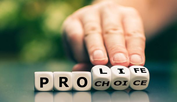 La mano gira los dados y cambia la expresión "pro choice" a "pro life"
". - Foto, imagen