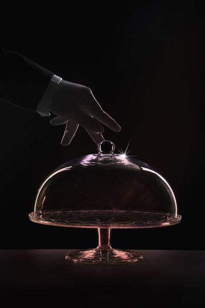 Human hand reaching out to dome of cake stand - 写真・画像