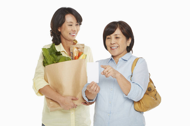 Women with groceries checking their shopping list - Zdjęcie, obraz