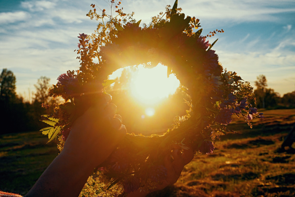 Szentivánéji tölgy és virágkoszorú sárga naplementében. Régi lett kulturális hagyomány LIGO. Szentivánéji ünnepség Lettországban. - Fotó, kép
