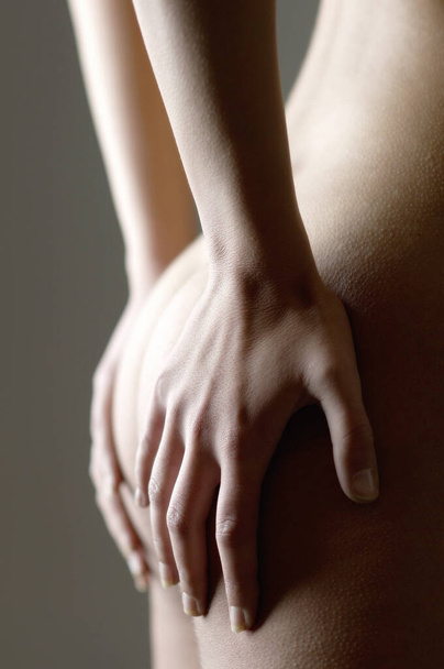 Woman touching her buttocks - Foto, afbeelding