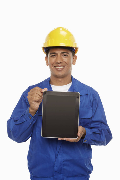 Construction worker holding up a digital tablet - Фото, изображение