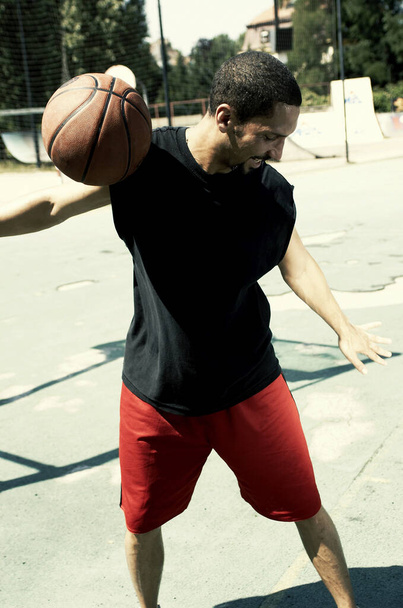 A basketball player rolling a ball from his left hand to his right hand - Foto, Imagen