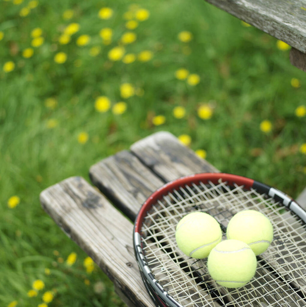 Tennis racquet and balls on the bench - Fotoğraf, Görsel