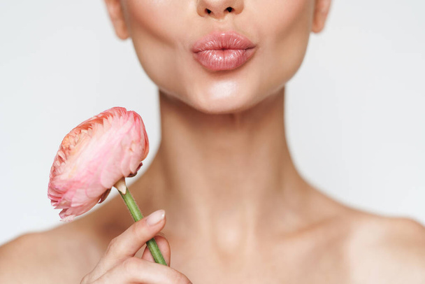 Cropped image of shirtless woman holding flower and making kiss lips isolated over white background - Φωτογραφία, εικόνα