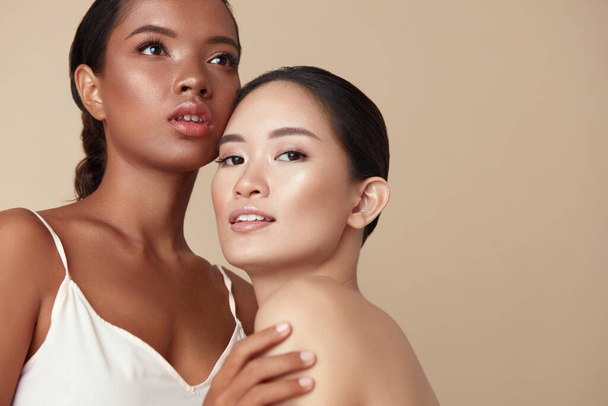 Beauty. Diverse Models Portrait With Copy Space For Advertising. Tender Asian And Mixed Race Women Posing Together On Beige Background. Female With Perfect Skin And Natural Makeup.  - Valokuva, kuva