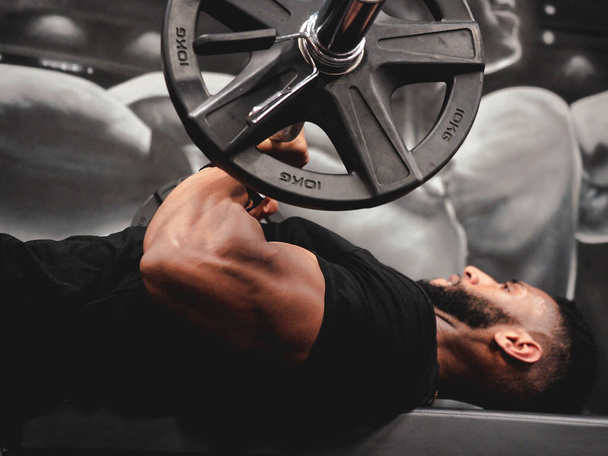 muskularny facet robi triceps rozszerzenia - Zdjęcie, obraz