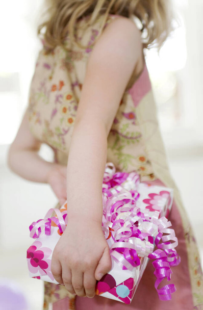 Girl holding a present in hand - Foto, imagen