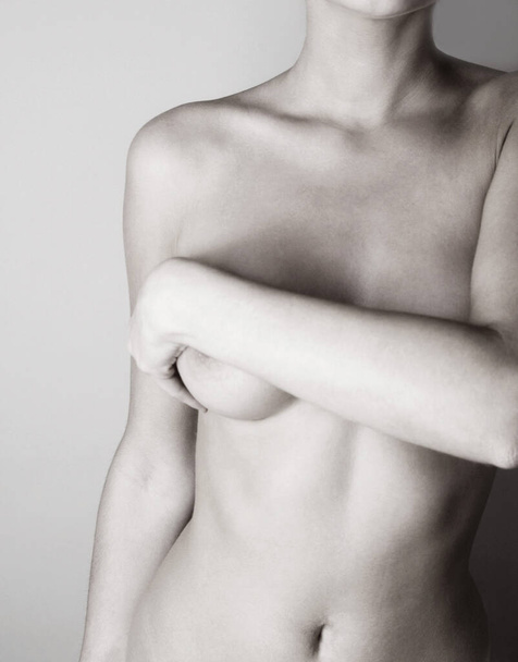 Topless woman covering her breasts with her hand - Photo, image