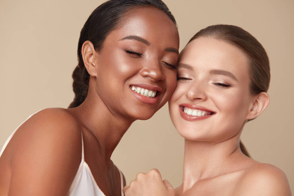 Beauty. Diversity Women Portrait. Happy Ethnic Models With Closed Eyes Standing Together Against Beige Background. Tender Caucasian And Mixed Race Female With Perfect Skin And Natural Makeup.  - Foto, Imagem