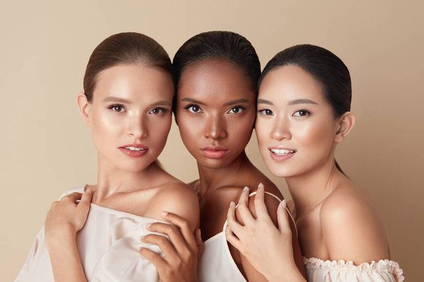 Beauty. Portrait Of Diversity Models. Mixed Race, Asian And Caucasian Girls Hugs Each Other And Looking At Camera. Different Ethnicity Women With Nude Makeup And Perfect Glowing Skin.  - Foto, immagini