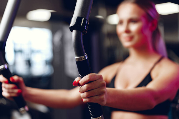 Blurred woman training arms and chest in a gym - Фото, зображення
