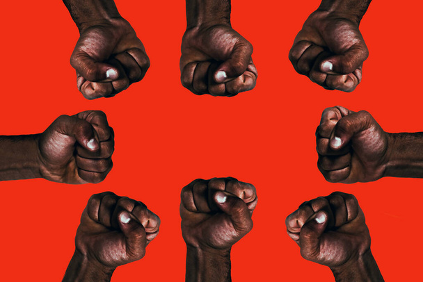 Punhos negros africanos unidos levantados pedindo liberdade e igualdade em um fundo vermelho
. - Foto, Imagem