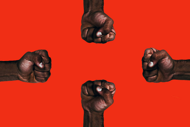 Krachtige Afrikaanse zwarte vuisten die oproepen tot vrijheid en gelijkheid op een rode achtergrond. - Foto, afbeelding