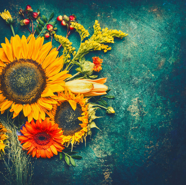 Autumn flowers arrangements made of  sunflowers, leaves and canina berries on rustic vintage background , top view, place for text, retro toned - Fotó, kép
