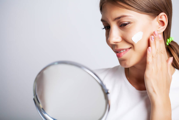 Hautpflege, junge Frau mit Schönheit Gesicht verwenden Gesichtshaut Creme - Foto, Bild