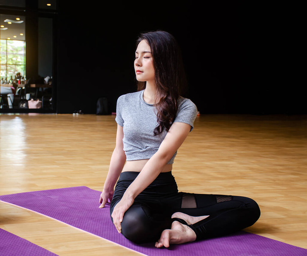 Jeune femme sportive personnes attrayantes pratiquant des cours de yoga avec pose de base avec instructeur, travailler à l'intérieur, studio. Bien-être, sport et santé concept - Photo, image